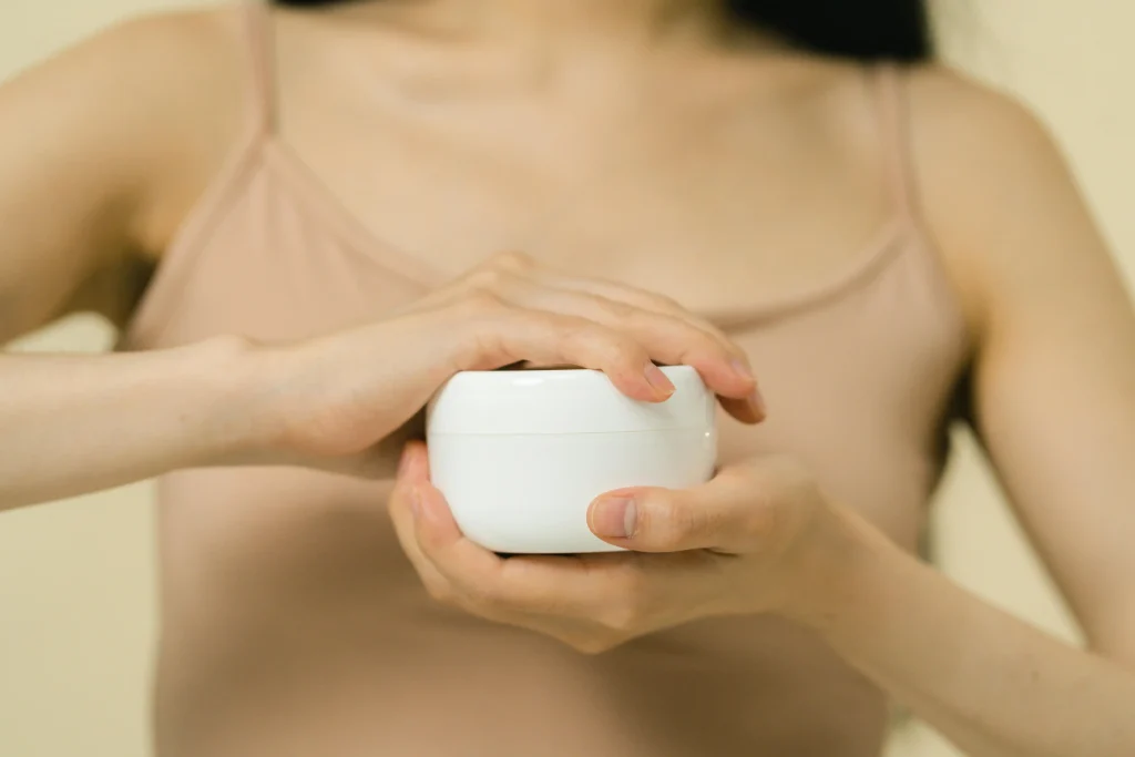 femme qui montre un pot de crème fermé