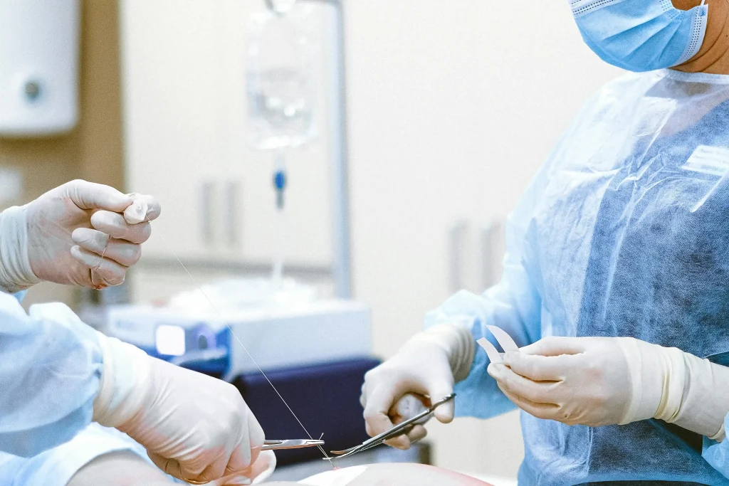 chirurgienne qui referme sa patiente après une chirurgie des ovaires